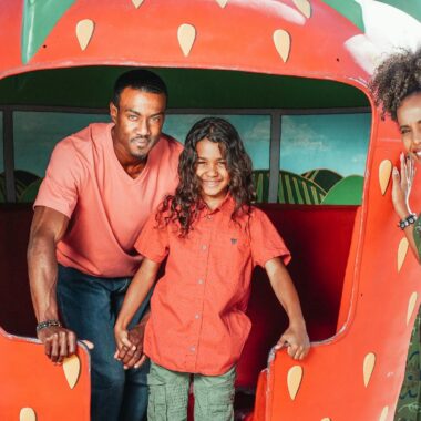 A joyful family enjoying a day out at the strawberry farm in summer.